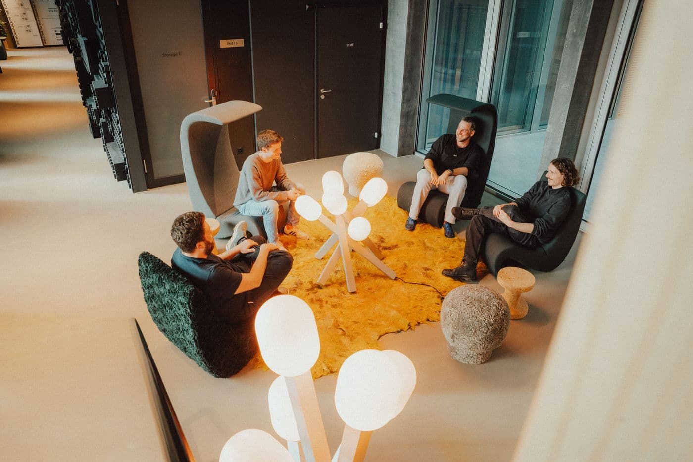 Vier formigas Kollegen sitzen gemeinsam in einer Runde im schweizer Office