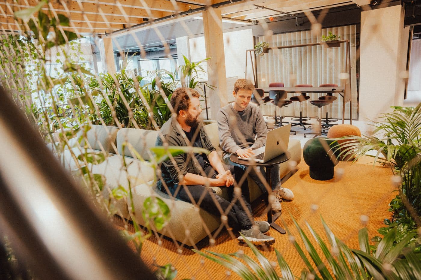 Zwei Mitarbeiter von formigas arbeiten in einer Sofa-Ecke gemeinsam an einem Laptop